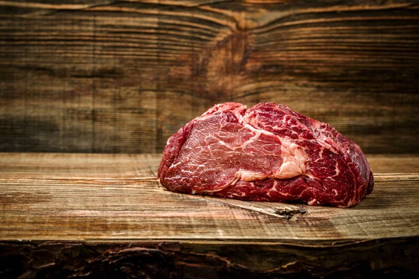 Suché věku Ribeye Steak s kořením na dřevěné pozadí. — Stock fotografie