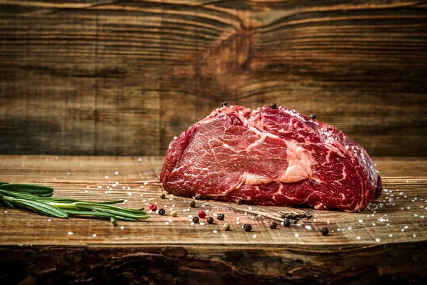 Hängmörad Ribeye Steak med smaksättning på trä bakgrund. — Stockfoto