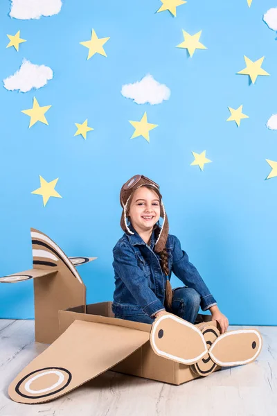 Bambina in costume da pilota sta giocando e sognando di volare sopra le nuvole . — Foto Stock