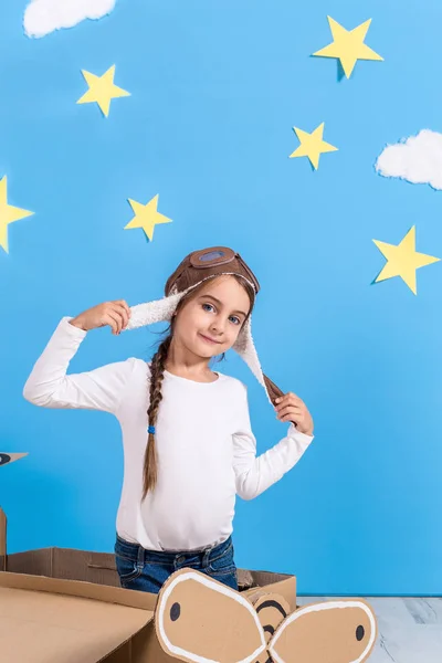 Bambina in costume da pilota sta giocando e sognando di volare sopra le nuvole . — Foto Stock