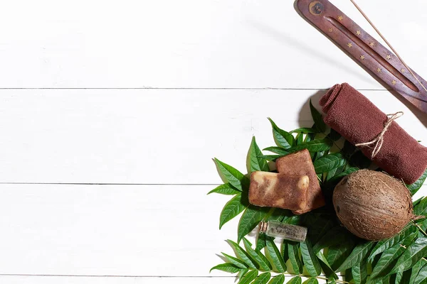 Kahverengi havlu, mavi kil ve doğal kahve soap üzerinde beyaz ahşap masa, üstten görünüm