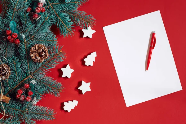 Red pen and notepad on red table decorated with a fir branch. The background for the text. — Stock Photo, Image