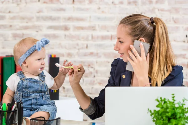 Family Business - telecommute Businesswoman and mother with kid is making a phone call