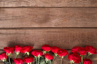 Ahşap masa üzerinde kırmızı gül buketi. Kopya alanı ile Üstten Görünüm.