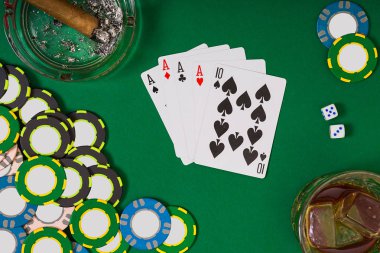 kumar, servet ve eğlence kavramı - casino fişi, viski cam, iskambil ve puro yeşil masa yüzeyi yakın