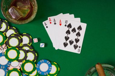kumar, servet ve eğlence kavramı - casino fişi, viski cam, iskambil ve puro yeşil masa yüzeyi yakın