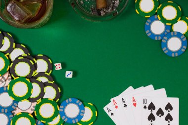 kumar, servet ve eğlence kavramı - casino fişi, viski cam, iskambil ve puro yeşil masa yüzeyi yakın