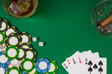 kumar, servet ve eğlence kavramı - casino fişi, viski cam, iskambil ve puro yeşil masa yüzeyi yakın