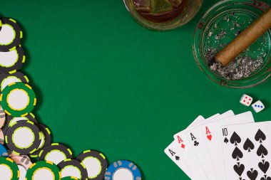kumar, servet ve eğlence kavramı - casino fişi, viski cam, iskambil ve puro yeşil masa yüzeyi yakın