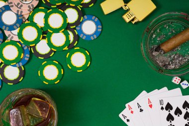 kumar, servet ve eğlence kavramı - casino fişi, viski cam, iskambil ve puro yeşil masa yüzeyi yakın