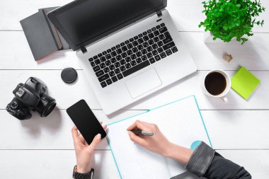 Düz yatıyordu, en iyi görünümü office tablo Resepsiyon. Çalışma alanıyla kızlar eller, dizüstü bilgisayar, bir pot, nane günlüğü, kahve kupa yeşil çiçek