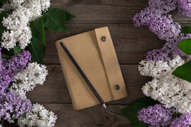Leylak çiçeği mesaj tebrik için defter rustik ahşap zemin üzerine. Üstten Görünüm