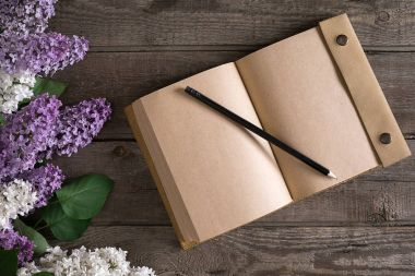Leylak çiçeği mesaj tebrik için defter rustik ahşap zemin üzerine. Üstten Görünüm