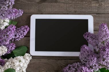 Leylak çiçeği tablet tebrik mesajı için boş alan ile rustik ahşap arka plan üzerinde. Üstten Görünüm