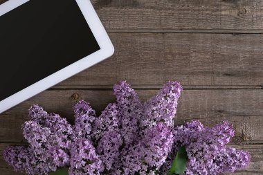 Leylak çiçeği tablet tebrik mesajı için boş alan ile rustik ahşap arka plan üzerinde. Üstten Görünüm