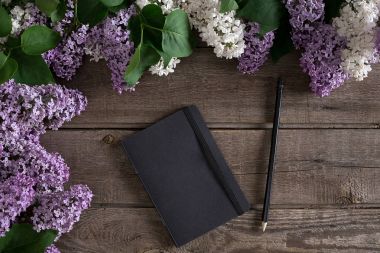 Leylak çiçeği mesaj tebrik için defter rustik ahşap zemin üzerine. Üstten Görünüm