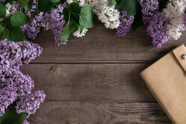 Leylak çiçeği mesaj tebrik için defter rustik ahşap zemin üzerine. Üstten Görünüm