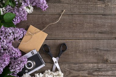 Leylak çiçeği mesaj tebrik için boş alanı rustik ahşap zemin üzerine. Makas, iplik makarası, küçük zarf. Üstten Görünüm