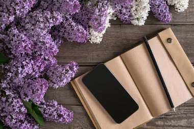 Leylak çiçeği mesaj tebrik için defter rustik ahşap zemin üzerine. Üstten Görünüm