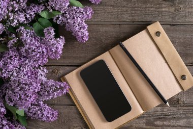 Leylak çiçeği mesaj tebrik için defter rustik ahşap zemin üzerine. Üstten Görünüm
