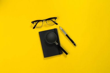 Office sarı bir arka plan üzerinde siyah nesnelerden. İş ve yaratıcılık. Üstten Görünüm.