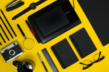 Office sarı bir arka plan üzerinde siyah nesnelerden. İş ve yaratıcılık. Üstten Görünüm.