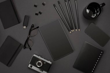 Office koyu gri arka plan üzerinde siyah nesnelerden. İş ve yaratıcılık. Üstten Görünüm.