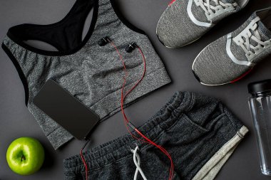 Fitness gıda ve donanımı ile egzersiz planı üzerinde gri arka plan, üstten görünüm