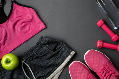 Sporcu kadın giyim ve şişe suyu ile koyu gri arka plan ayarla