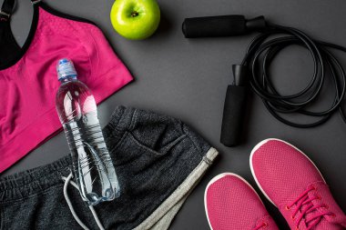 Kadın giyim, spor ayakkabı ve gri arka plan üzerinde su şişe ile sporcular ayarla