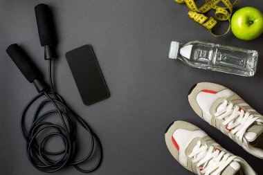 Fitness gıda ve donanımı ile egzersiz planı üzerinde gri arka plan, üstten görünüm