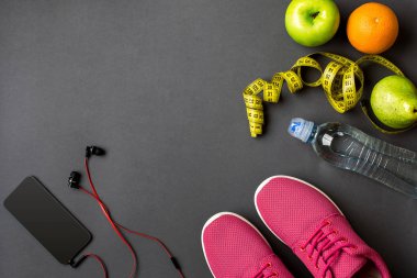 Fitness gıda ve donanımı ile egzersiz planı üzerinde gri arka plan, üstten görünüm