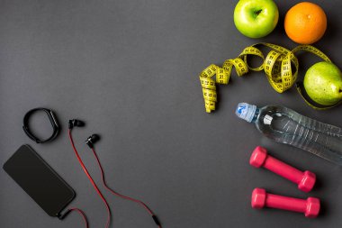 Fitness gıda ve donanımı ile egzersiz planı üzerinde gri arka plan, üstten görünüm