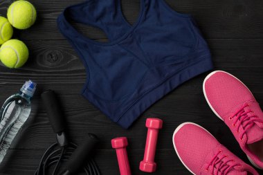 Kadın giyim, spor ayakkabı, şişe su koyu arka plan üzerinde ile sporcular ayarla