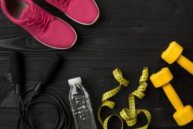 Kadın giyim, spor ayakkabı, şişe su koyu arka plan üzerinde ile sporcular ayarla