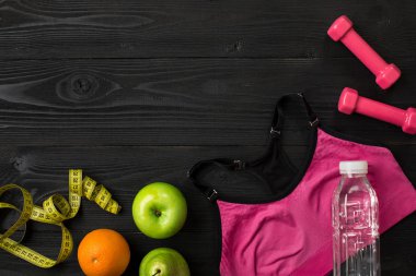 Fitness ekipmanları ile egzersiz planı üzerinde koyu arka plan, üstten görünüm