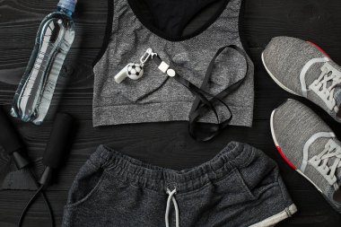 Sporcu kadın giyim ve şişe suyu ile koyu arka plan üzerinde ayarla