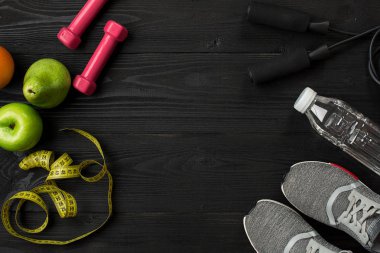 Kadın giyim, spor ayakkabı, şişe su koyu arka plan üzerinde ile sporcular ayarla