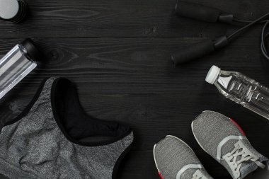 Kadın giyim, spor ayakkabı, şişe su koyu arka plan üzerinde ile sporcular ayarla