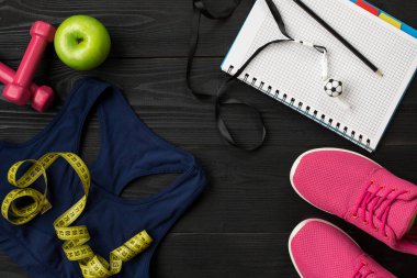 Fitness ekipmanları ile egzersiz planı üzerinde koyu arka plan, üstten görünüm