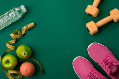 Sporcu kadın giyim ve şişe suyu ile yeşil arka plan ayarla