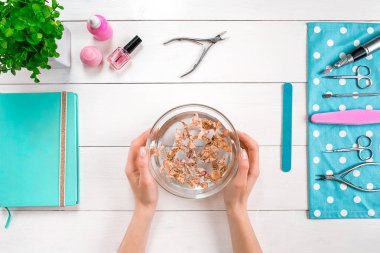 Kadın el bakımı. Profesyonel tırnak bakım araçları ile güzel pürüzsüz kadının el beyaz arka plan üzerinde üstten görünüm koltuklu saç yıkama teknesi.