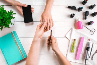 Manikür için istemci. Bir manikürcü ve istemci bir ahşap zemin üzerine Close-Up