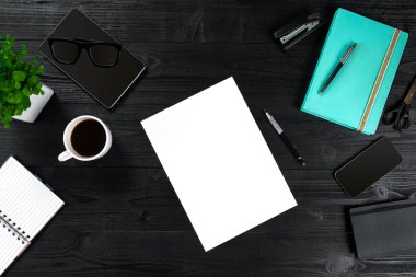 Üstten görünümüyle kopya alanı ofis masaları, notebook fincan kahve ve akıllı fon ile