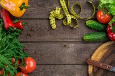 Sebze ve ölçü birimi teyp diyet ahşap arka plan üzerinde. Üstten Görünüm.