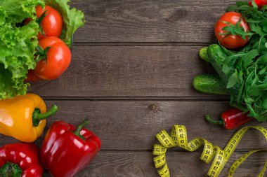 Sebze ve ölçü birimi teyp diyet ahşap arka plan üzerinde. Üstten Görünüm.