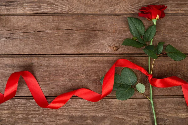 木製の背景、トップ ビューでリボンと美しい赤いバラ。愛またはバレンタインの日の概念 — ストック写真
