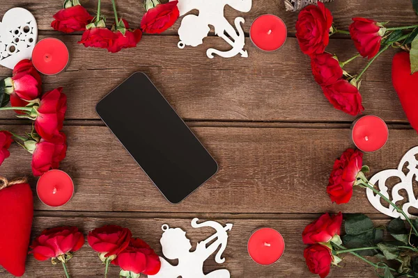Red roses, candles and hearts over wood with copy space. Valentines day background
