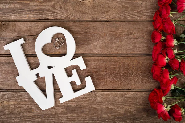 Ahşap masa üzerinde kırmızı gül buketi. Üstten Görünüm kopya alanı ile. çiçekler