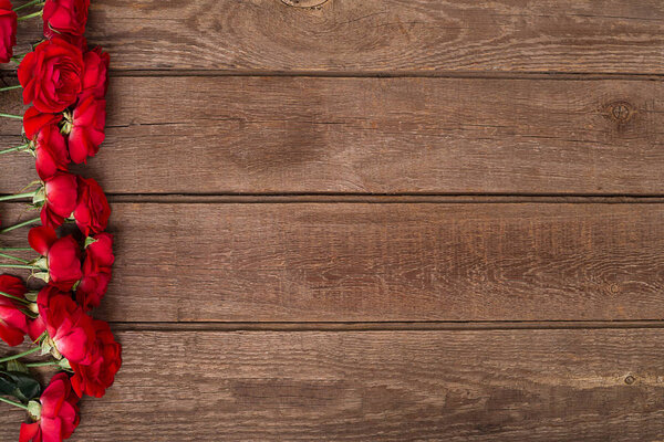 Red roses bouquet over wooden table. Top view with copy space. flowers